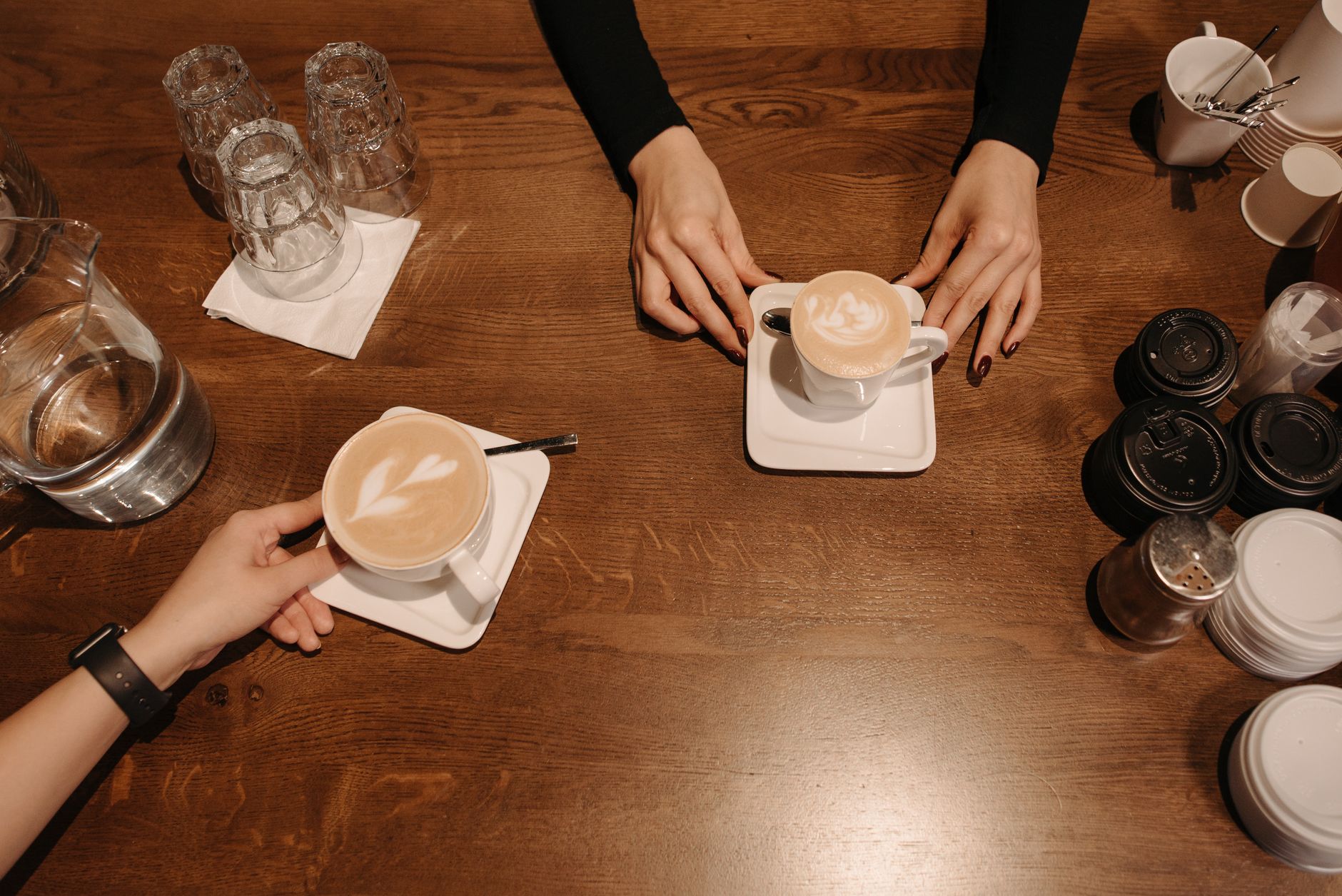 Warm coffee cups with latte art on wooden table